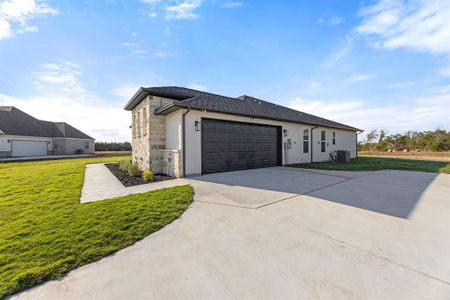 View of home's exterior featuring a garage, central air condition unit, and a lawn