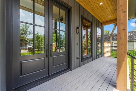 The large, covered front porch offers Fiberon Composite flooring and the front door is adorned with Kwisket Hardware and Keyless Entry.