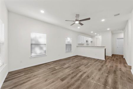 Unfurnished living room with ceiling fan and hardwood / wood-style floors