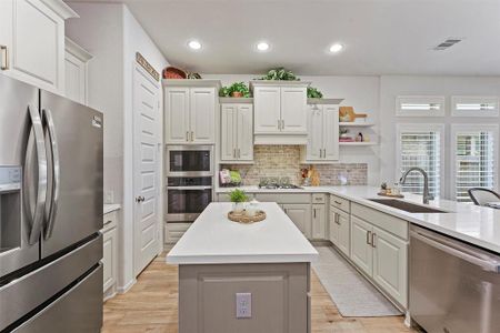 This gourmet kitchen boasts a gas cooktop, custom hardware, accented paint colors, and upgraded cabinetry.