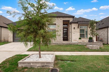 View of front of house featuring a garage and a front lawn