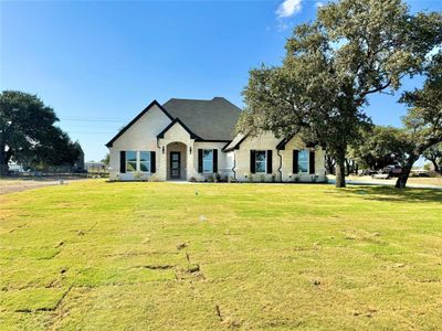 French provincial home featuring a front yard