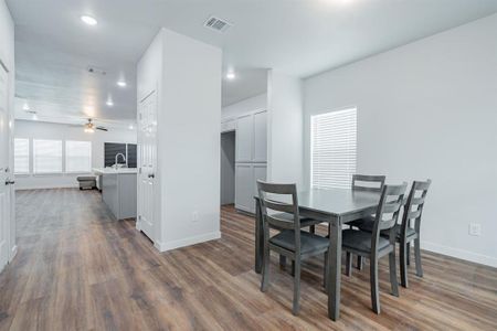 Dining room with dark hardwood / wood-style flooring and ceiling fan