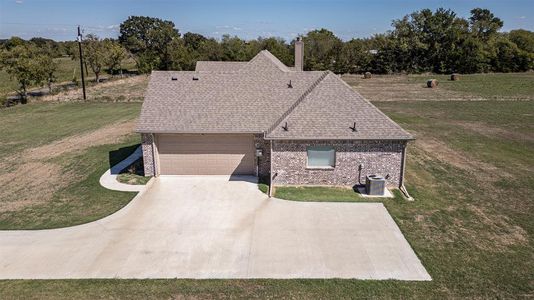 View of front of home with a garage and a front lawn