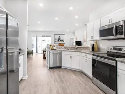 Enjoy a sunny kitchen, open to the gathering room - New home for sale in Auburndale, FL. Photo showcases the home layout - you choose the finishes to personalize this home! Furniture and decor items not included.