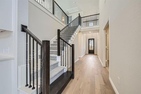 Entryway featuring a towering ceiling and light hardwood / wood-style flooring