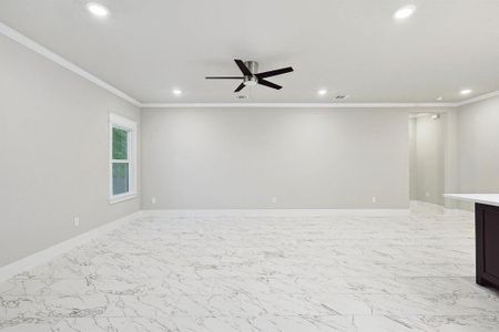 Unfurnished room featuring ceiling fan, crown molding, and light tile flooring