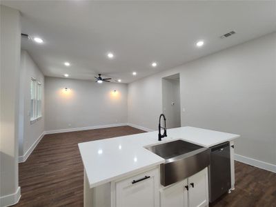 Kitchen with white cabinets, a kitchen island with sink, sink, and dark hardwood / wood-style flooring