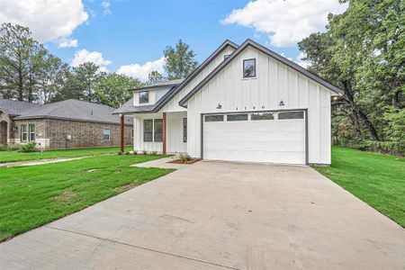 Modern inspired farmhouse featuring a front yard and a garage