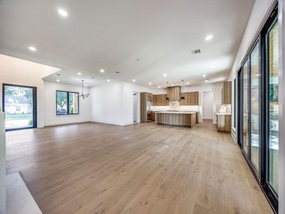 Unfurnished living room with light hardwood / wood-style flooring and an inviting chandelier