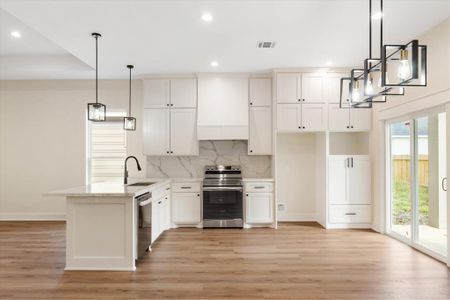 Welcome home! This breathtaking kitchen showcases floor-to-ceiling solid wood cabinetry, luxurious quartz countertops, and plenty of room for extra seating. Every detail is thoughtfully designed, including an under-mount stainless steel sink, a built-in dishwasher, and a custom microwave nook. Don't miss the striking, custom vent hood!