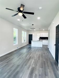 Unfurnished living room featuring sink, hardwood / wood-style flooring, and ceiling fan