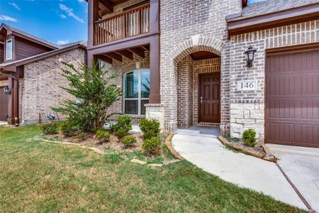 Property entrance with a lawn, a balcony, and a garage