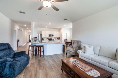 Living room with light hardwood / wood-style flooring and ceiling fan