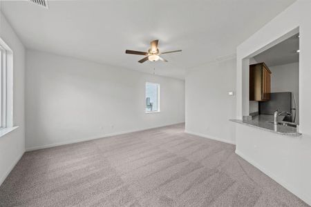 Living room featuring ceiling fan and carpet flooring