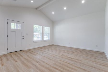 Entrance foyer with high vaulted ceiling, beamed ceiling, and light hardwood / wood-style flooring