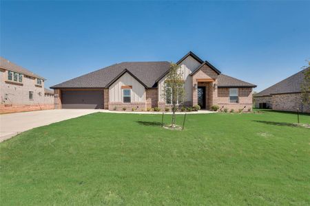 View of front of house with a garage, a front lawn, and central AC