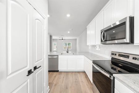 Kitchen featuring spacious 2 door- pantry, Whirlpool appliances, and view of dining area.