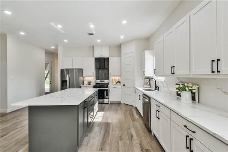 All cabinets have matte black hardware to match the vent hood and kitchen faucet.