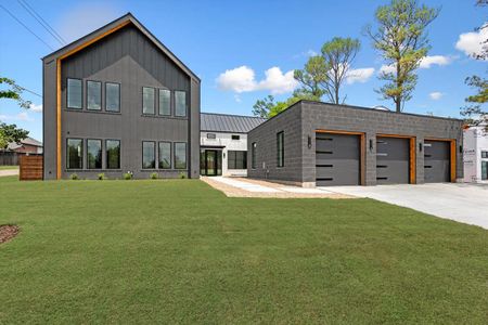 Rear view of house with a garage and a yard