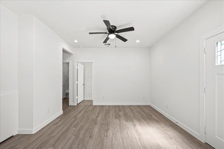 Spacious and open, featuring a ceiling fan and recessed lighting.