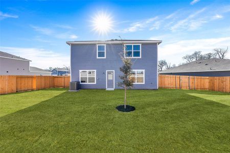 Back of property with cooling unit and a lawn