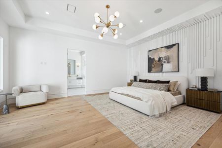 Primary Bedroom Suite with custom paneled vestibule entry, custom accent wall, fitted closet, recessed LED lighting and chandelier