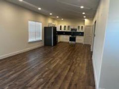 Unfurnished living room featuring dark wood-type flooring