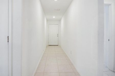 Hall featuring light tile patterned floors