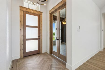 Entryway featuring french doors and light parquet flooring