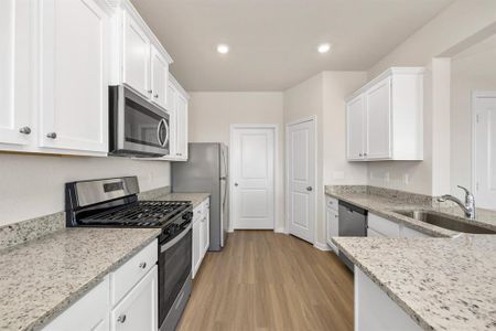 Indulge in culinary bliss in this gourmet kitchen, where sleek stainless steel meets timeless elegance. Granite countertops, white cabinets, and a sprawling walk-in pantry make every meal prep a joyous occasion.