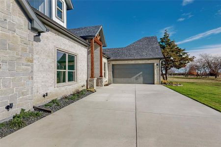 View of side of property featuring a lawn and a garage