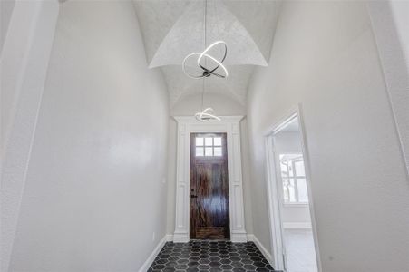 Entryway with custom tile patterned flooring, groin ceiling, custom millwork at door.