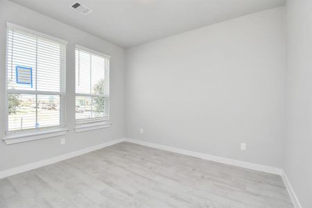 Quietly nestled in front of the home is the sophisticated home office. Featuring elegant tile, custom paint and large window. Sample photo of completed home with similar floor plan. Actual colors and selections may vary.