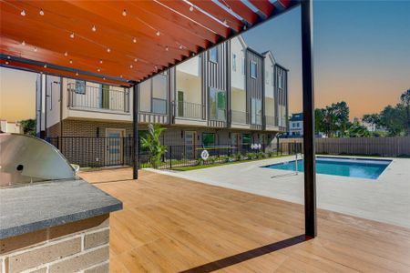 Pool at dusk featuring exterior kitchen