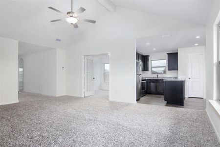 Kitchen with high vaulted ceiling, ceiling fan, beamed ceiling, and carpet floors