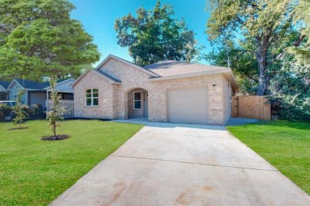 View of front of house featuring a front lawn and a garage