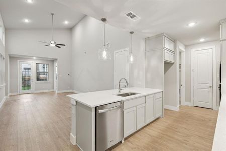 Kitchen with light hardwood / wood-style floors, sink, ceiling fan, a center island with sink, and stainless steel dishwasher