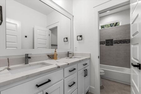 Hallway Full bathroom with tiled shower / bath, vanity, and toilet