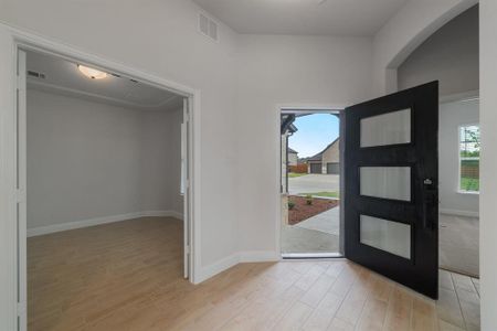 Foyer featuring light wood-type flooring and vaulted ceiling