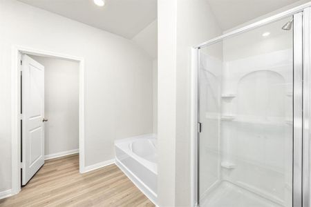 Luxurious primary bathroom with walk-in closets and a separate standing shower.