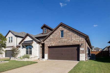 View of front facade featuring cooling unit, a front lawn, and a garage