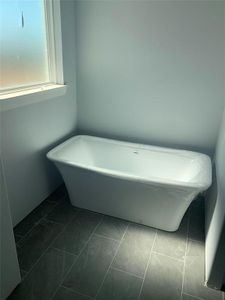 Bathroom featuring a bath and tile patterned flooring