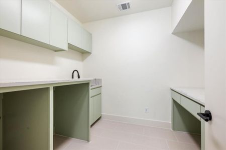 Laundry area with sink and light tile patterned floors