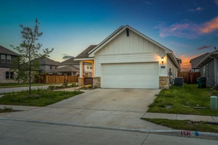 Craftsman inspired home featuring central AC unit, a garage, and a lawn