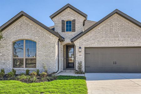 View of front of property featuring a front lawn and a garage