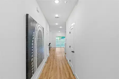 Corridor with light hardwood / wood-style flooring