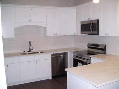 Kitchen with stainless steel appliances, quartz countertops