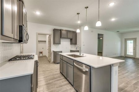 Gorgeous kitchen features stainless steel appliances, an island and pendant lighting.