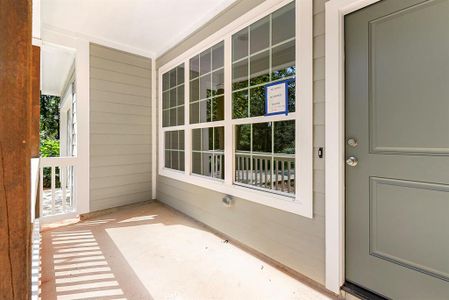 Lovely, country style front porch.  Exterior paint is gray with a charming green door.